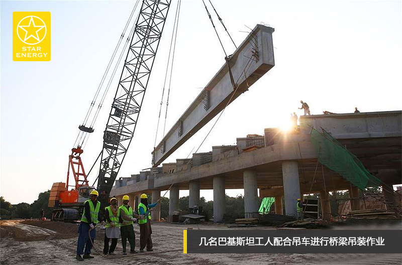 幾名巴基斯坦工人配合吊車進(jìn)行橋梁吊裝作業(yè)